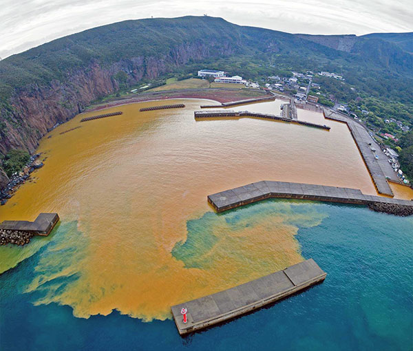 図4 現在の鉄沈殿場：鹿児島県薩摩硫黄島(鬼界カルデラの外輪山が陸上にみられる。酸性温泉が流出し、海洋が酸性化している。)