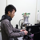 <span class="qrinews-figure-title">2010年12月14日 学部4年の大庭さん</span>　ラマン分光器を用いてアセトンのdynamicsについて調べています。（撮影場所：<a href="http://frontier.phys.kyushu-u.ac.jp/liquid-phys/" target="_blank">構造物性研究室</a>）