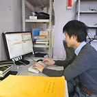 <span class="qrinews-figure-title">2011年1月14日 修士2年の輿石さん</span>　スピンモデルを用いた量子相転移の解析を行っています。（撮影場所：<a href="http://www.stat.phys.kyushu-u.ac.jp/" target="_blank">統計物理学研究室</a>）