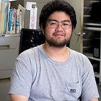 <span class="qrinews-figure-title">2011年6月14日 博士1年の久保さん</span>　ゲージ／重力対応を用いてクォークの閉じ込めのある場の理論を研究しています。2枚目の写真は&ldquo;原子核素粒子三者若手 夏の学校&rdquo;での発表の様子です。（撮影場所：<a href="http://higgs.phys.kyushu-u.ac.jp/" target="_blank">素粒子論研究室</a>）