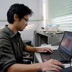 <span class="qrinews-figure-title">2011年10月20日 修士2年の崎山さん。</span>　粒子法を用いて地球大気の流れをシミュレーションしています。（撮影場所：<a href="http://gfd.geo.kyushu-u.ac.jp/" target="_blank">地球流体力学研究室</a>）