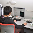 <span class="qrinews-figure-title">2012年6月7日 修士2年の倉本さん</span>　シミュレーションを用いて粉流体中の音波の伝播を研究しています。（撮影場所：<a href="http://www.stat.phys.kyushu-u.ac.jp/" target="_blank">統計物理学研究室</a>）