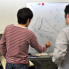 <span class="qrinews-figure-title">2012年6月22日 坂上助教</span>　分野はソフトマター物理で、ゆらぐひもの物理を研究しています。写真は、中島特任助教(5/15掲載)との議論中です。（撮影場所：<a href="http://www.stat.phys.kyushu-u.ac.jp/" target="_blank">統計物理学研究室</a>）