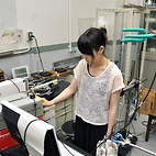 <span class="qrinews-figure-title">2012年8月3日 学部4年の荒木さん</span>　地震が引き金となる噴火のメカニズムを解明する実験をしています。（撮影場所：<a href="http://ganseki3.geo.kyushu-u.ac.jp/" target="_blank">岩石循環科学研究室</a>）