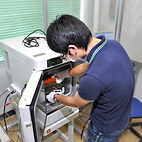 <span class="qrinews-figure-title">2012年8月28日 修士1年の宮崎さん</span>　次世代加速器実験用デバイスの基礎特性を測定しています。（撮影場所：<a href="http://epp.phys.kyushu-u.ac.jp/" target="_blank">素粒子実験研究室</a>）