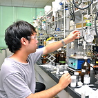 <span class="qrinews-figure-title">2012年10月11日 修士2年の中村さん</span>　生加水分解による光学活性アミノ酸の合成について研究しています。（撮影場所：<a href="http://www.scc.kyushu-u.ac.jp/Hiheikou/" target="_blank">触媒有機化学研究室</a>）
