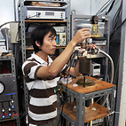 <span class="qrinews-figure-title">2012年11月1日 修士1年の内山さん</span>　液体ヘリウムを用いた低温での電子状態を測定しています。（撮影場所：<a href="http://frontier.phys.kyushu-u.ac.jp/LTP/yayama/" target="_blank">低次元電子物性研究室</a>）