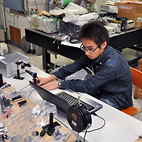 <span class="qrinews-figure-title">2012年11月28日 学部4年の安東さん</span>　真空中に50μｍサイズの液滴を作り出す装置を開発しています。（撮影場所：<a href="http://www.scc.kyushu-u.ac.jp/quantum/index_j.php" target="_blank">量子化学研究室</a>）