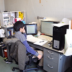 <span class="qrinews-figure-title">2012年12月4日 博士3年の榮田さん</span>　有効場理論を用いて2核子の散乱を解析しています。（撮影場所：<a href="http://higgs.phys.kyushu-u.ac.jp/" target="_blank">素粒子理論研究室</a>）