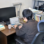 <span class="qrinews-figure-title">2013年1月7日 博士2年の吉本さん</span>　冷却原子系におけるWilsonくりこみ群を用いた解析について研究しています。（撮影場所：<a href="http://higgs.phys.kyushu-u.ac.jp/" target="_blank">素粒子理論研究室</a>）