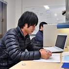 <span class="qrinews-figure-title">2013年1月9日 修士2年の中矢さん</span>　三項モデルを用いて数理ファイナンスについて研究しています。（撮影場所：<a href="http://www.math.kyushu-u.ac.jp" target="_blank">数理学研究教育棟 院生室1</a>）