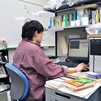 <span class="qrinews-figure-title">2013年1月22日 博士3年の山岡さん</span>　文法ルールを厳格に当てはめる機械翻訳のプログラムを作成しています。（撮影場所：<a href="http://www.math.kyushu-u.ac.jp" target="_blank">数理学研究教育棟 院生室4</a>）