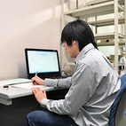 <span class="qrinews-figure-title">2013年4月22日 博士1年の山田さん</span>　非平衡定常状態の関係式について研究しています。（撮影場所：<a href="http://www.cmt.phys.kyushu-u.ac.jp/ja/" target="_blank">物性理論研究室</a>）