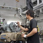 <span class="qrinews-figure-title">2013年6月10日 修士1年の田尾さん</span>　実験で用いるヘリウムガスを再利用する循環系を作成しています。（撮影場所：<a href="http://www.kutl.kyushu-u.ac.jp/" target="_blank">原子核物理研究室</a>）
