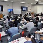 <span class="qrinews-figure-title">2014年6月26日 生物学科の講義風景</span>　今日の写真は生物学科学部3年生用の講義の様子です。伊藤先生の分子神経生物学の講義です。遠隔講義システムを利用して伊都地区からも受講できるようになっていました。（撮影場所：<a href="https://maps.google.co.jp/maps?q=33.626591,130.425364+(here)&z=18" target="_blank">シス生セミナー1，2</a>）
