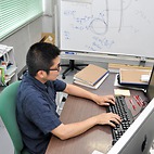 <span class="qrinews-figure-title">2014年9月1日 博士1年の大石さん</span>　荷電レプトンフレーバー非保存過程の探索の為の検出器開発をしています。素粒子物理学の標準模型を超える理論予測を検証する実験です。（撮影場所：<a href="http://epp.phys.kyushu-u.ac.jp" target="_blank">素粒子実験研究室</a>）