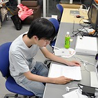 <span class="qrinews-figure-title">2014年10月15日 修士1年の小柳さん</span>　文字列でよく使われるデータ構造を利用した効率的なデブリングラフの作成に興味があります。（撮影場所：<a href="http://str.i.kyushu-u.ac.jp/" target="_blank">文字列情報学・機械学習理論研究室</a>）