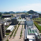 <span class="qrinews-figure-title">2015年5月26日 伊都の理学部からの風景</span>　理学部の建物からセンターゾーンの辺りを眺めた風景です。10階＋190cmくらいの高さからの撮影です。食堂の方への通路も建設中です。（撮影場所：<a href="https://maps.google.co.jp/maps?q=33.596581,130.221092" target="_blank">伊都キャンパス</a>）