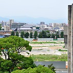 <span class="qrinews-figure-title">2015年8月20日 工学部があった辺り</span>　キャンパス移転に伴い、箱崎キャンパスの工学部があった辺りでは閉鎖建物の解体が進んでいます。周りを囲っていたフェンスも部分的に外されています。（撮影場所：<a href="https://maps.google.co.jp/maps?q=33.623589,130.424998" target="_blank">五十周年記念講堂付近</a>）